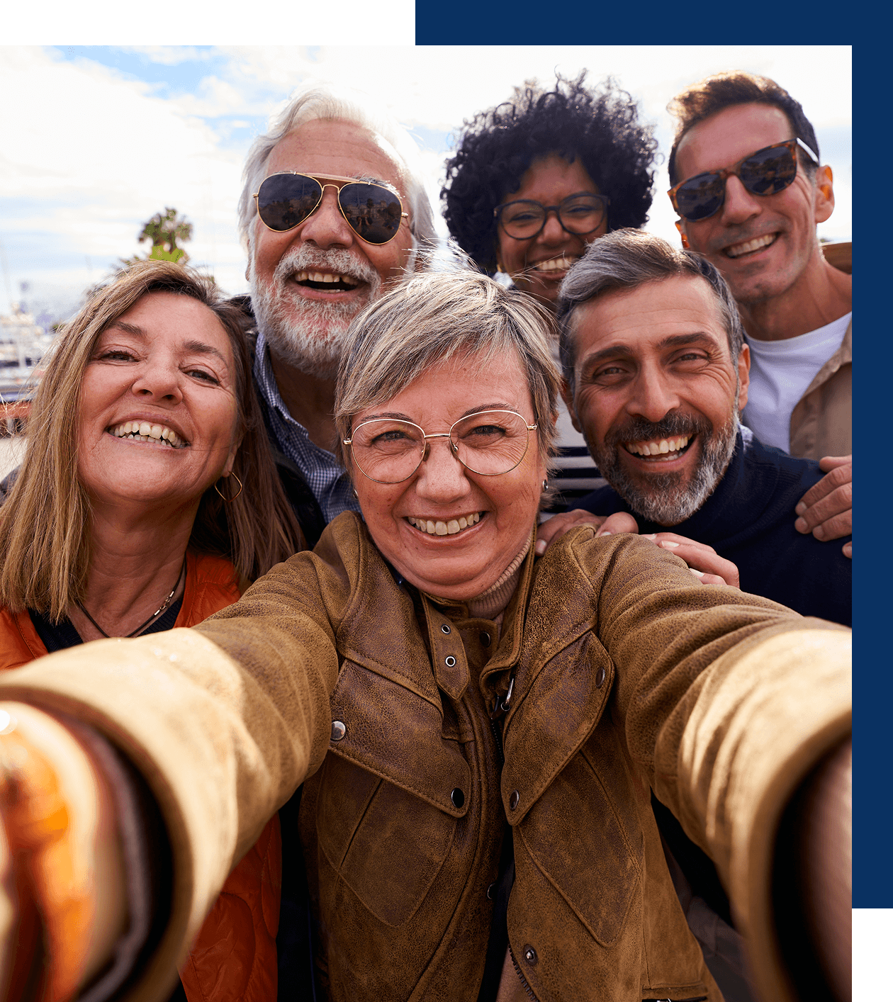 Group selfie with happy, smiling people outdoors.