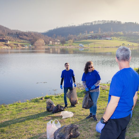 Volunteers cleaning litter by the lakeside.