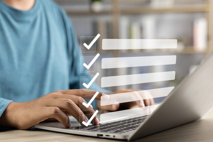Person typing on laptop with checklist overlay.