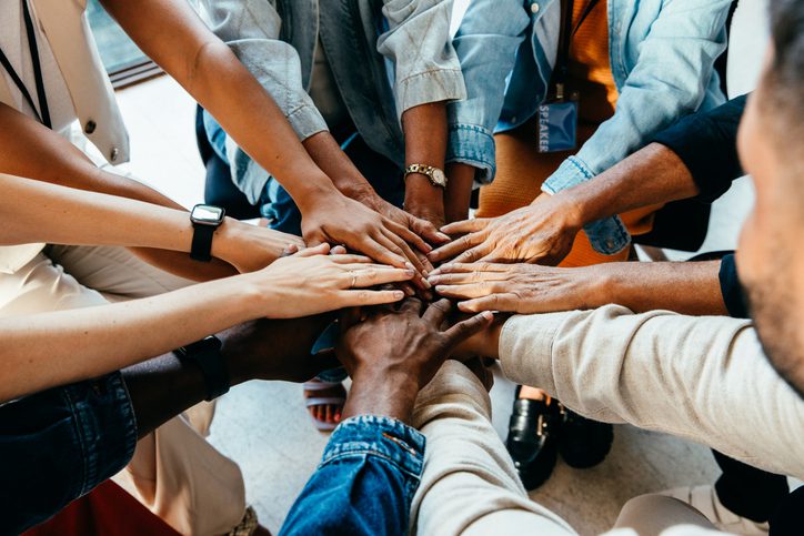 Hands joined together in a supportive circle.