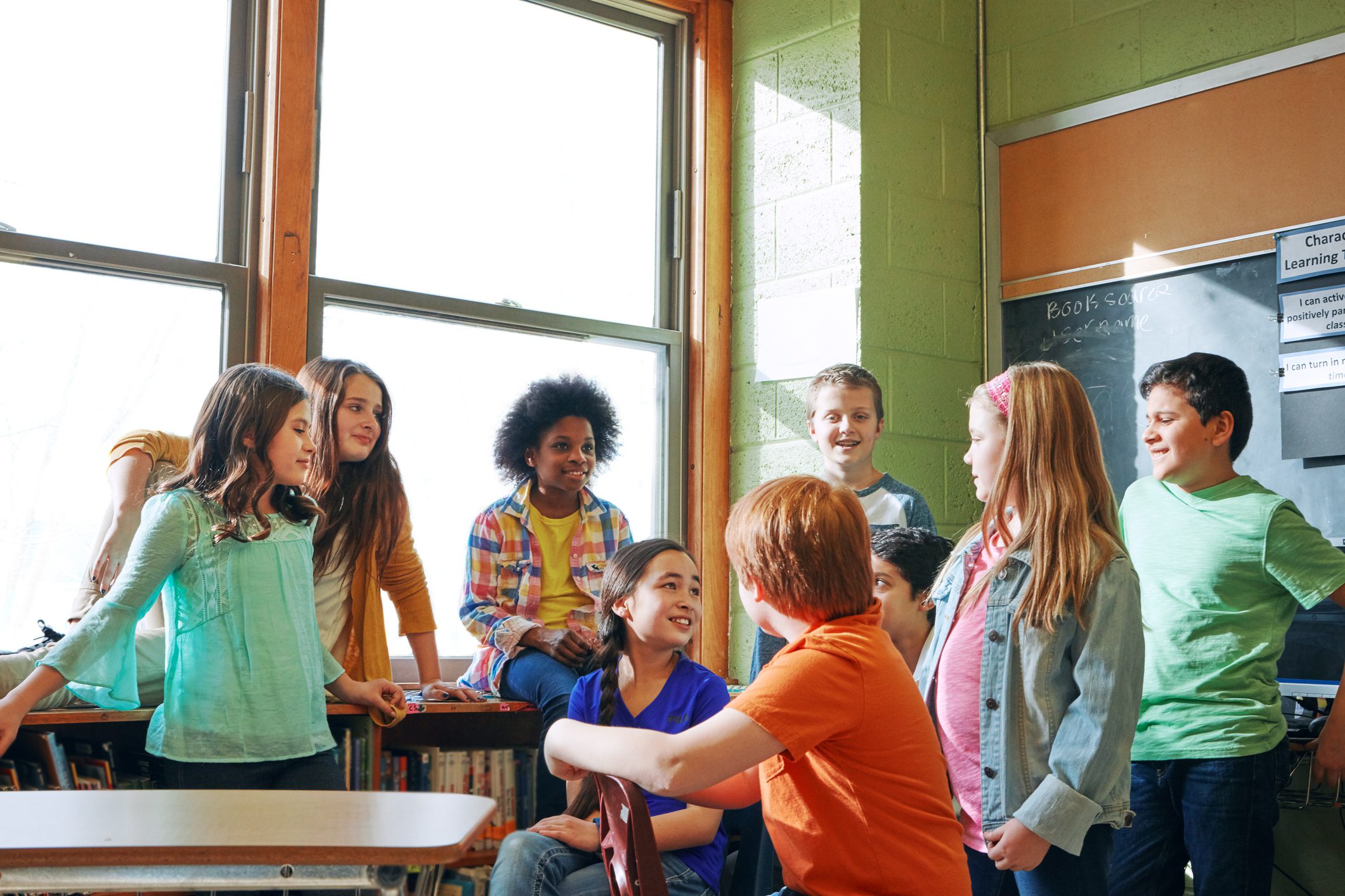 Students talking and laughing in a classroom.
